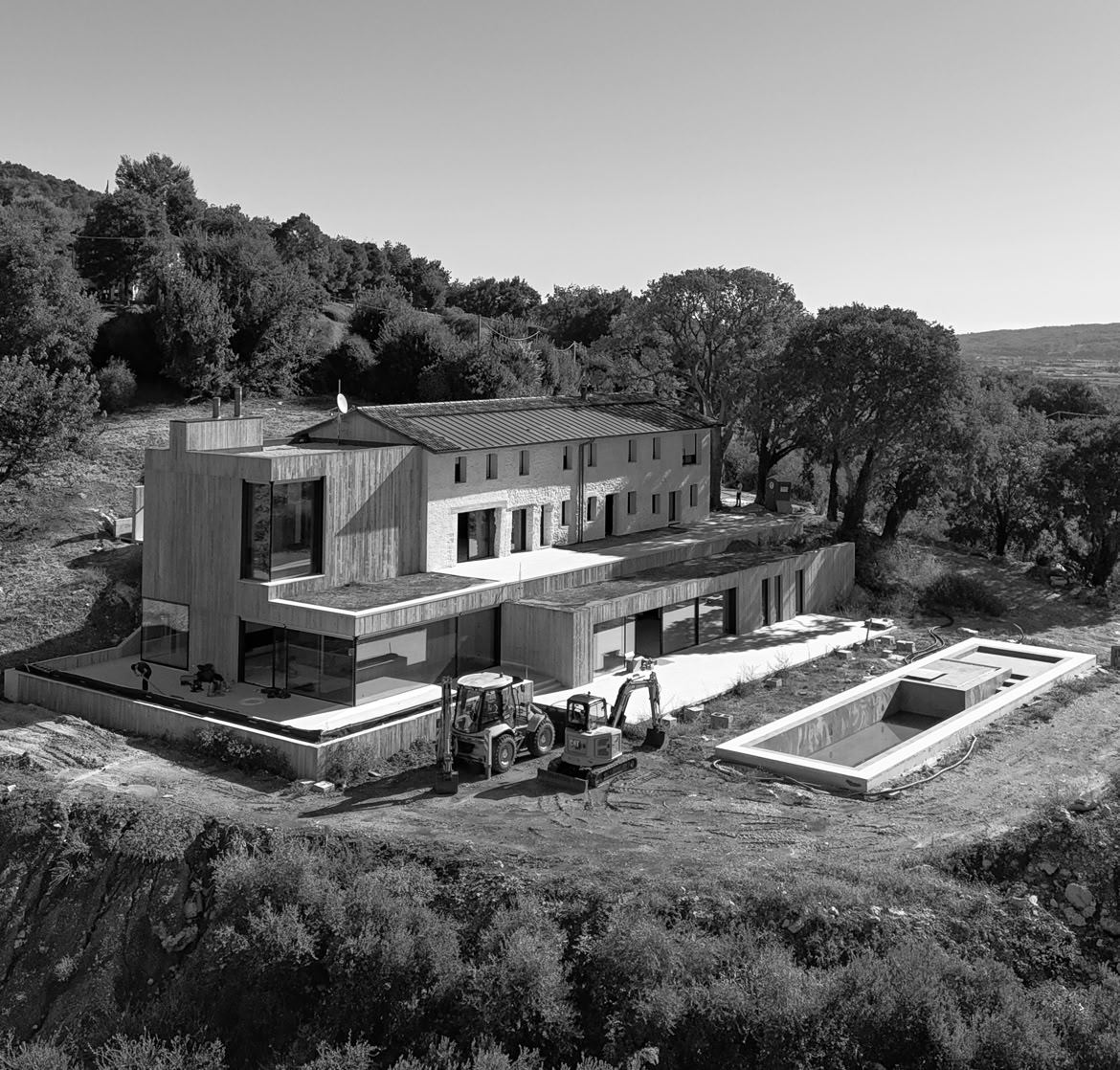 Vista esterna del casale rivisitato in chiave contemporanea. Un grande piscina a sfioro completa la sistmazione del giardino della residenza esclusiva.