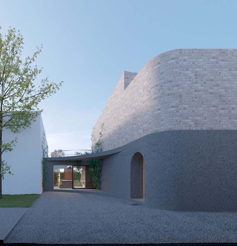 Vista frontale dell’edificio con geometria irregolare e dialogo con la vegetazione.