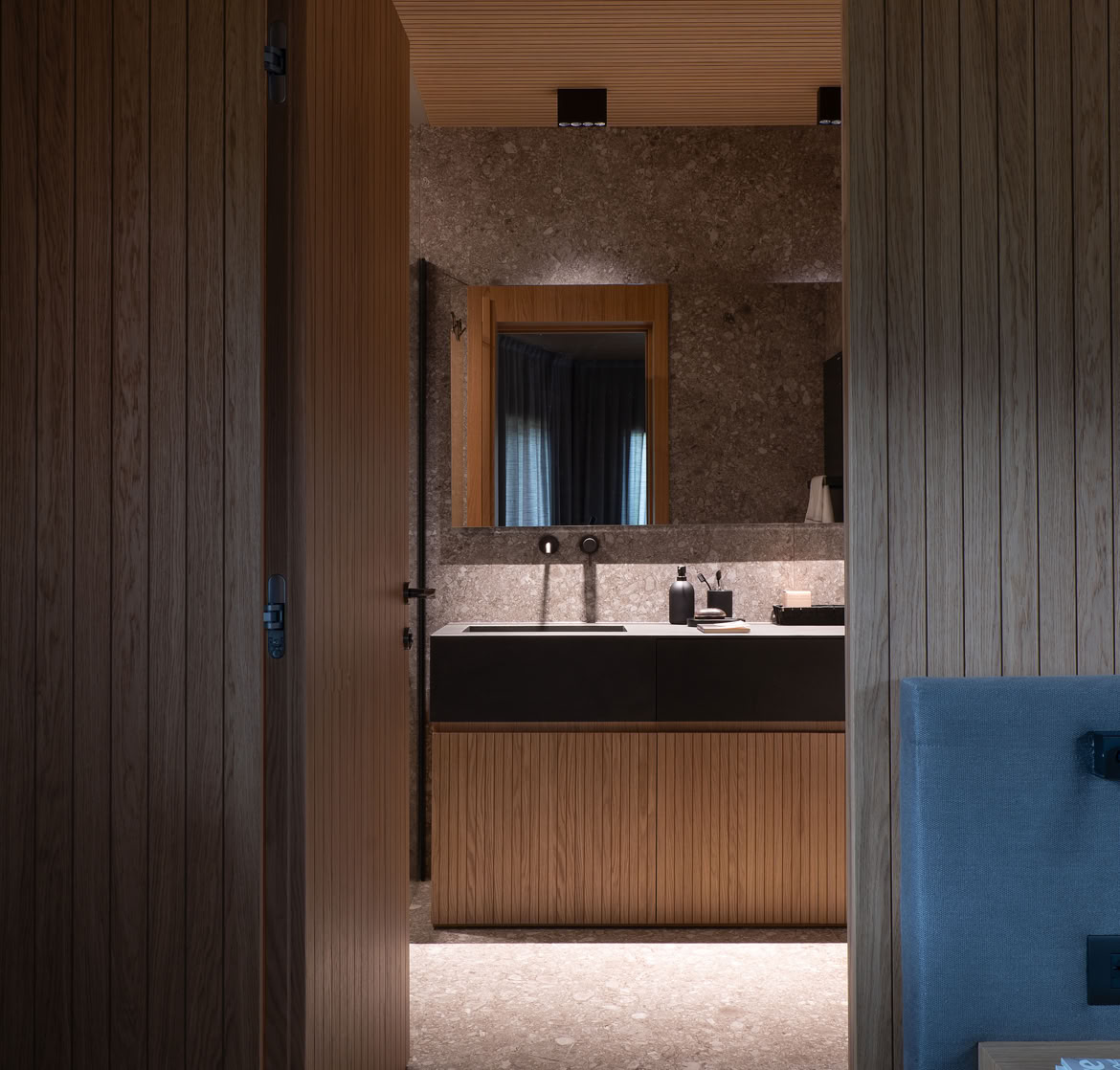 Spazio intimo e accogliente con rivestimenti in rovere naturale e arredi contemporanei.