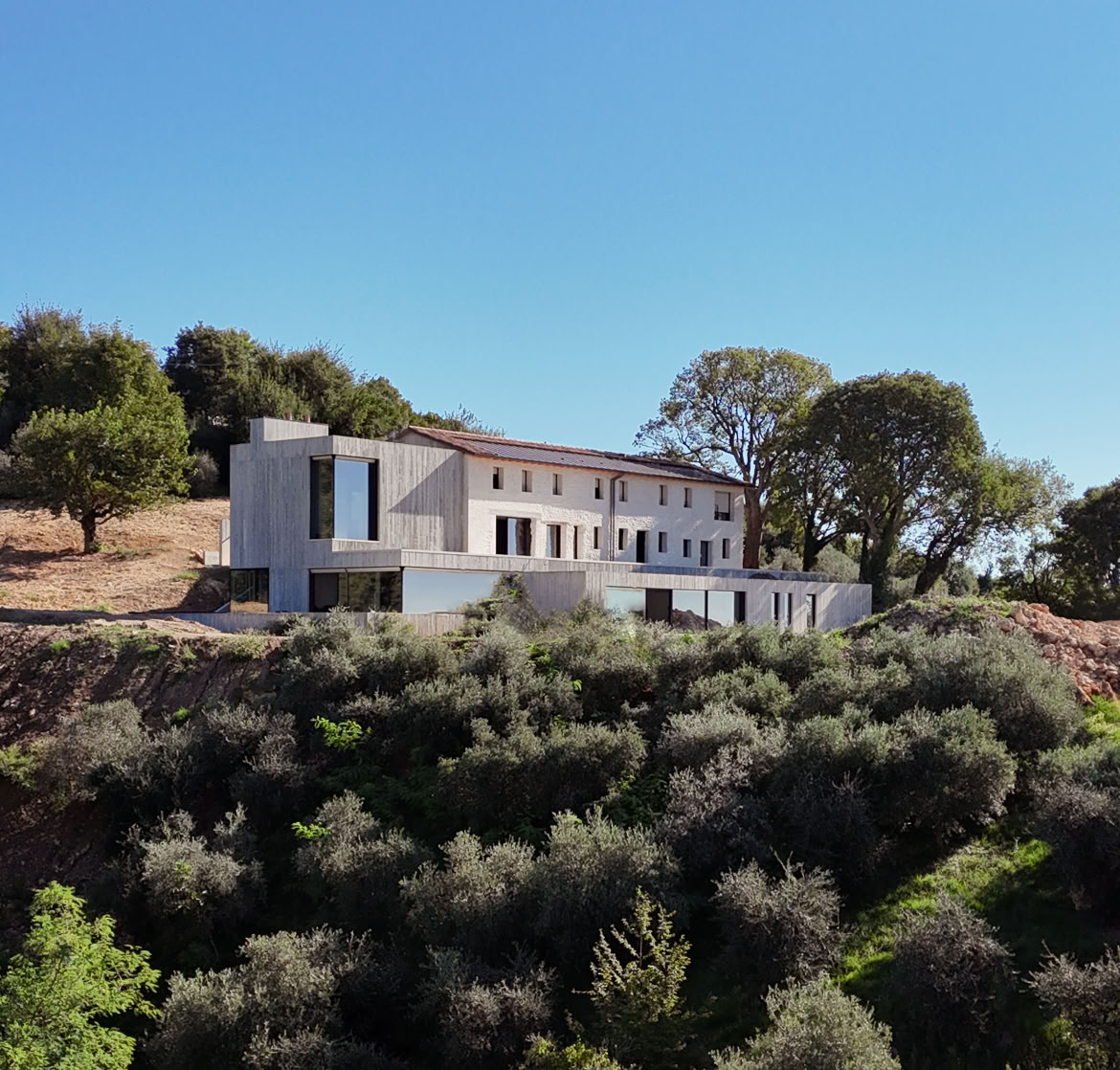 Facciata del casale ristrutturato in pietra naturale sulle colline di Treviso. Un esempio di architettura rurale in chiave contemporanea.