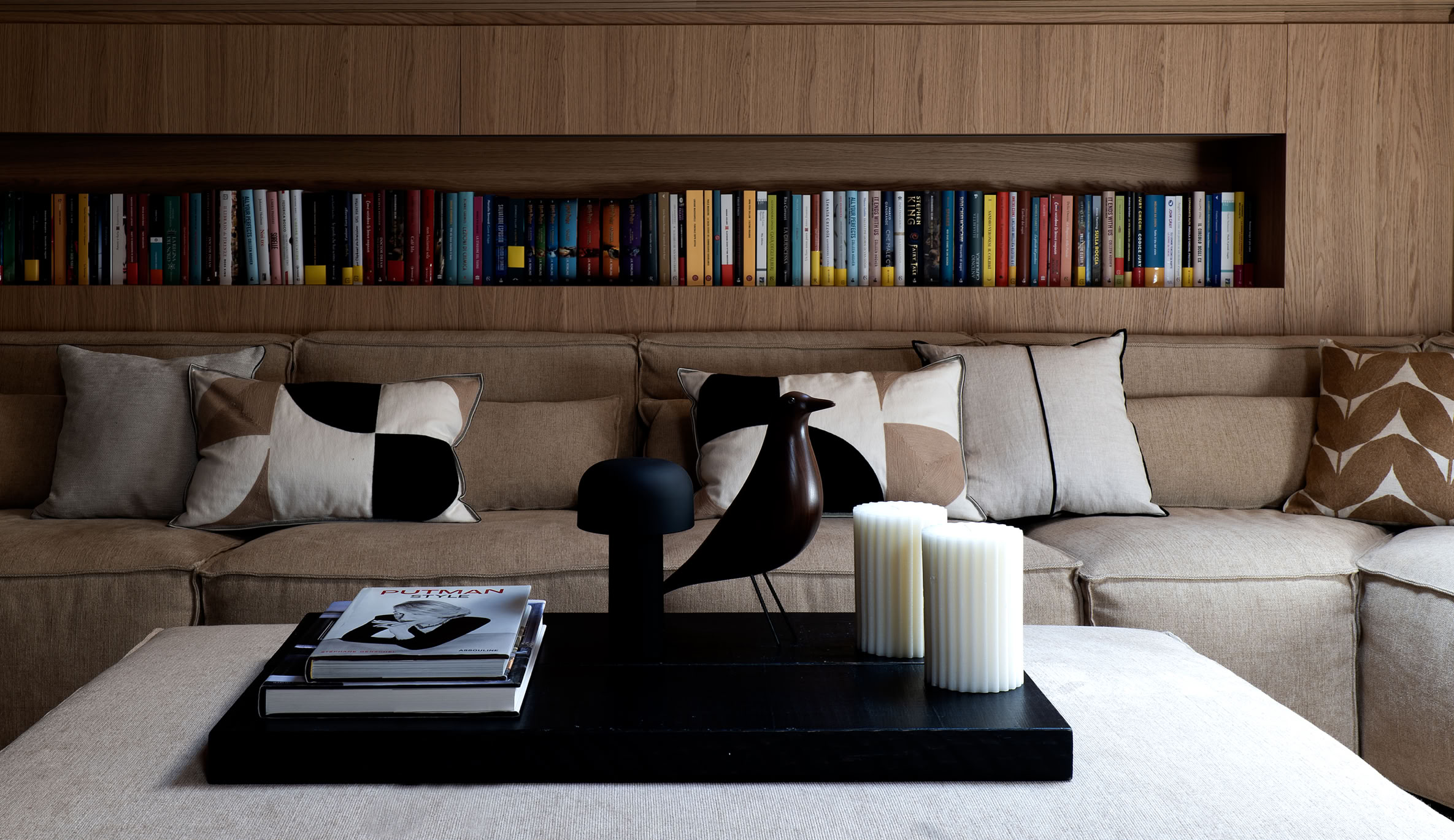 Ampio soggiorno arredato con divano e poltrone di design, caratterizzato da luce naturale e finiture in legno.
