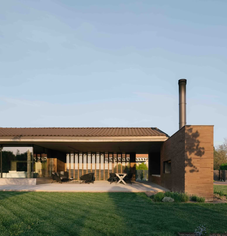 Contemporary brick villa by MIDE architetti featuring panoramic terrace, large windows, open-plan living, and refined interiors. A harmonious dialogue between architecture, light, and landscape.