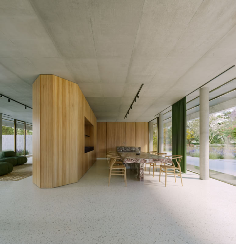 Contemporary living area interior, with large panoramic glass walls, premium materials, and a design that maximizes natural light and the connection with the outdoor spaces.