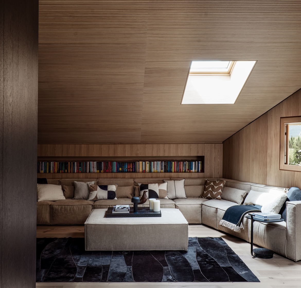 Ampio soggiorno arredato con divano e poltrone di design, caratterizzato da luce naturale e finiture in legno.