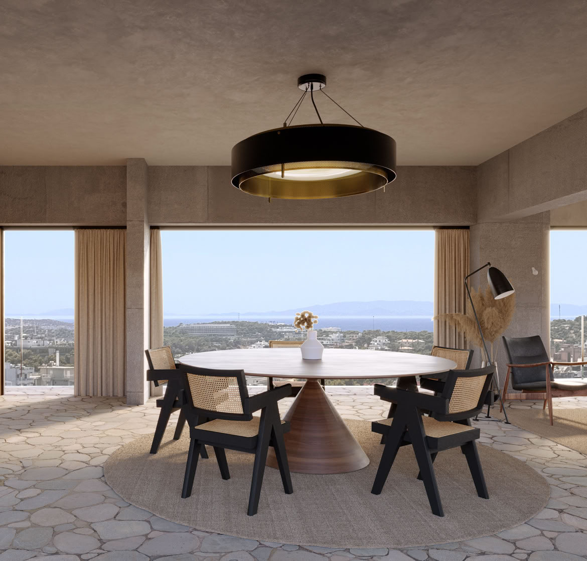Zona giorno open-space con cucina e sala da pranzo integrate, progettata per massimizzare la luce naturale e il rapporto con il giardino e il mare.