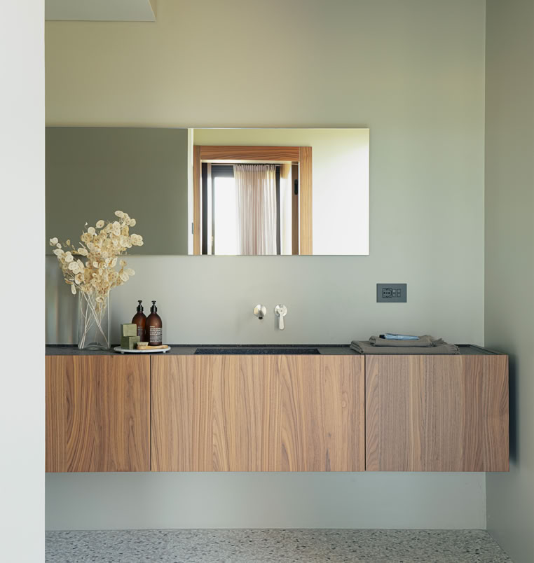 I toni naturali e le linee minimali definiscono il design di questo bagno padronale, creando un’atmosfera raffinata e rilassante all’interno della residenza contemporanea.