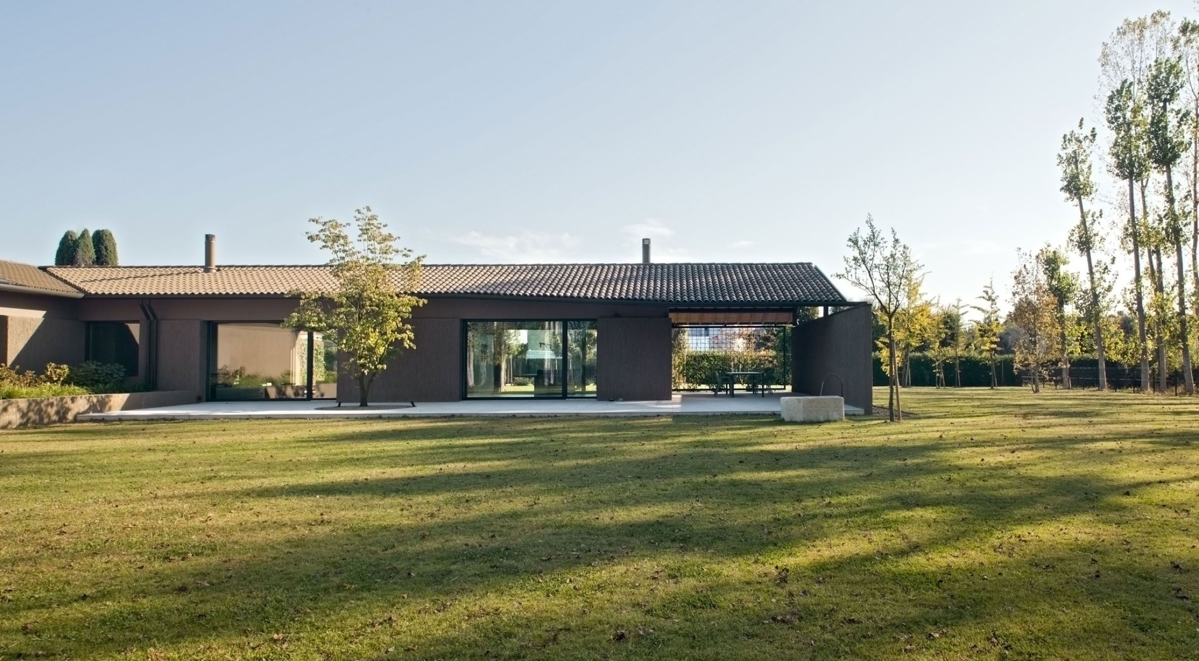 Villa contemporanea a Noale progettata da MIDE architetti, immersa nel paesaggio rurale veneto tra luce naturale e materiali materici.