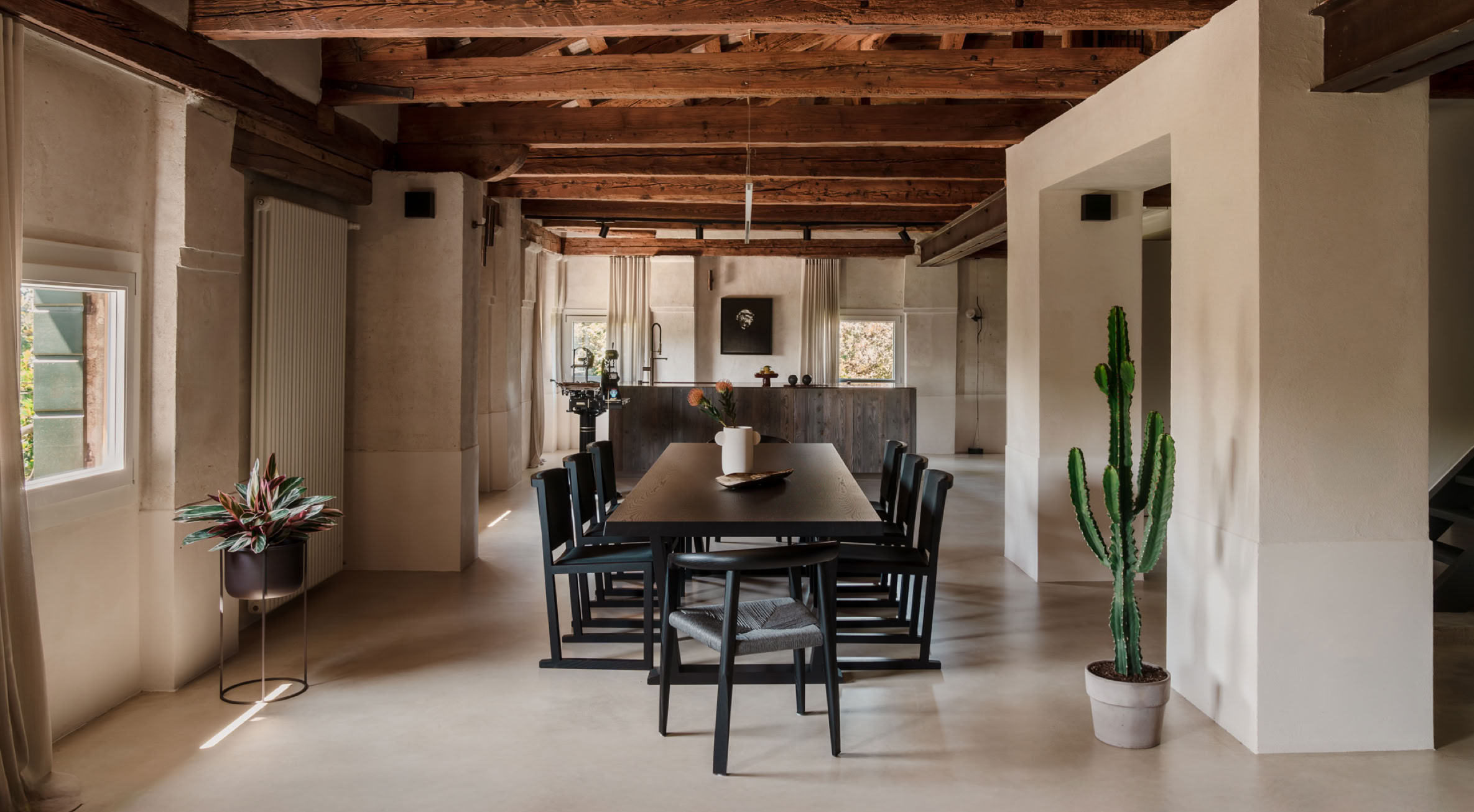 L’open space affacciato sul fiume unisce soggiorno, sala da pranzo e cucina in un ambiente fluido e luminoso, esaltando la continuità degli spazi.