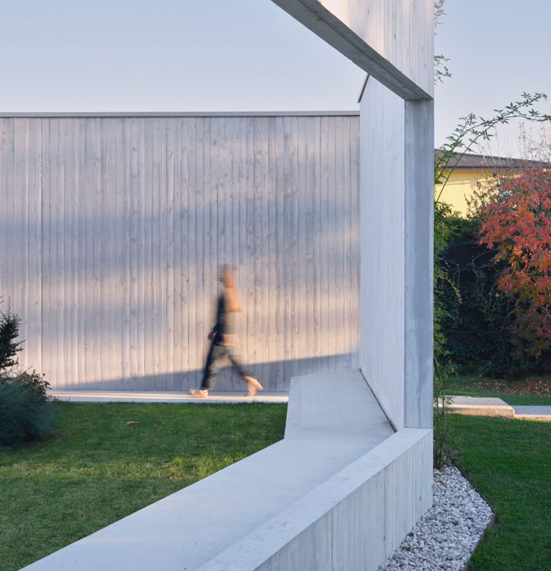 Vista esterna della villa a San Donà di Piave progettata da MIDE architetti immersa nel verde e disegnata con geometrie pulite che regalano privacy all'abitazione.