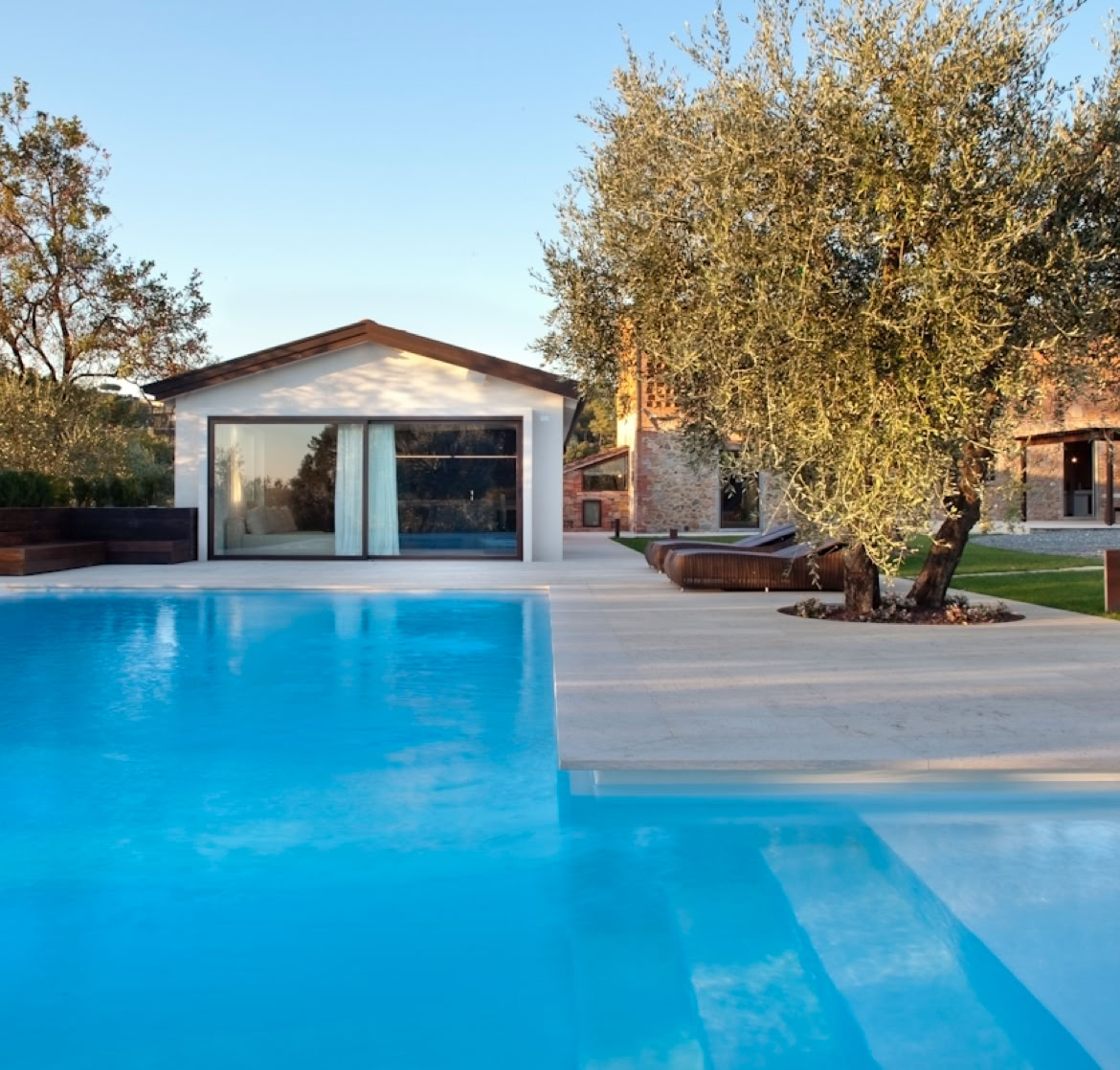 Piscina panoramica integrata nel giardino, pensata per godere del paesaggio naturale e della vegetazione mediterranea.