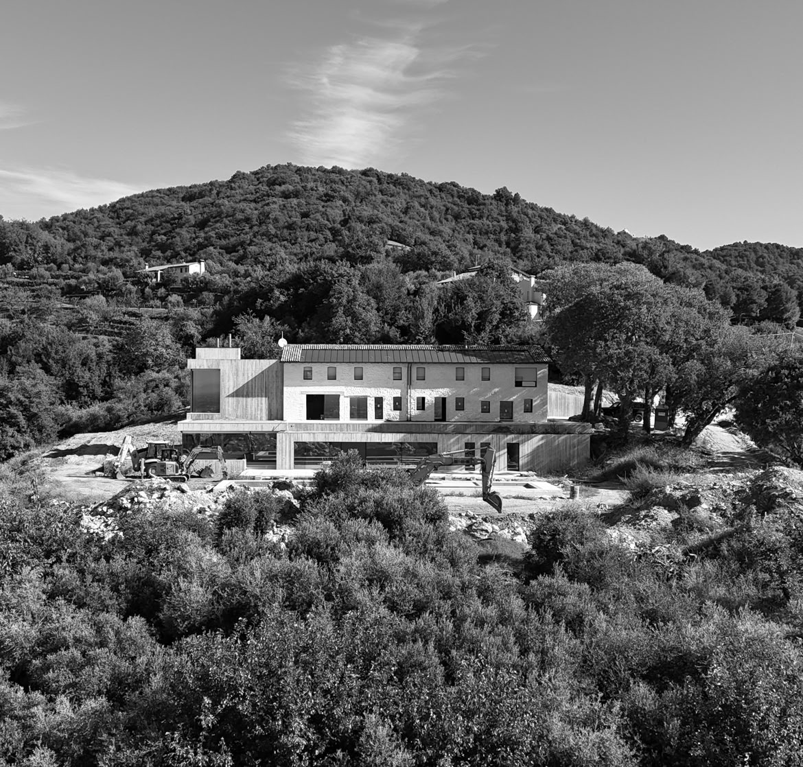 Retro del casale risrtrutturato con ampliamento in chiave contemporanea firmato MIDE architetti. Il casale si adagia sul pendio della collina integrandosi armoniosamente con il contesto circostane.