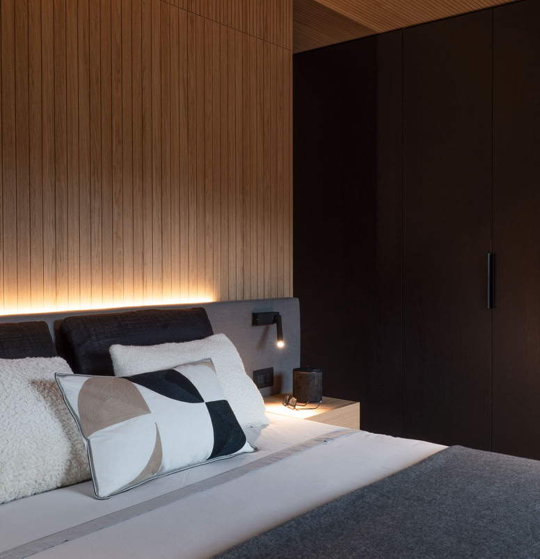 Spazio intimo e accogliente con rivestimenti in rovere naturale e arredi contemporanei.