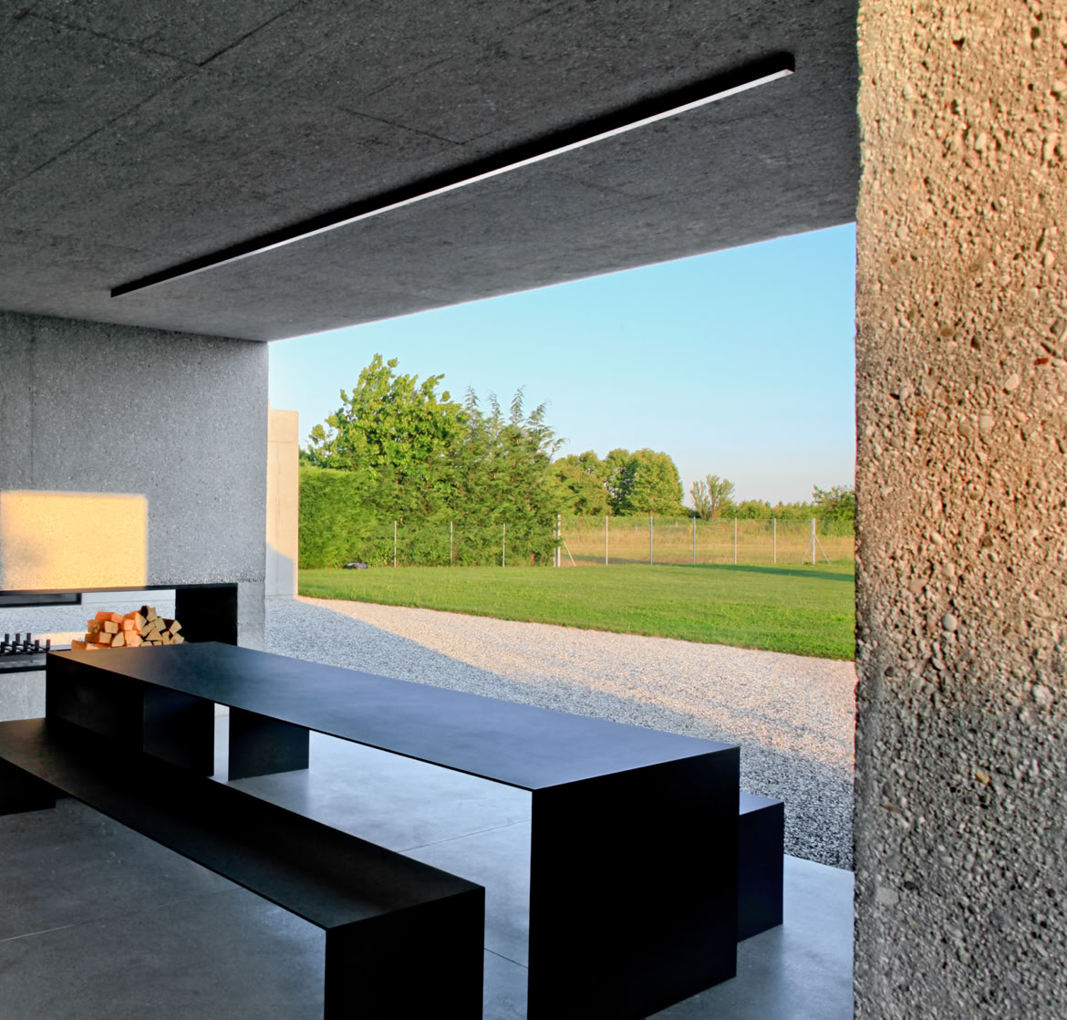 Giardino privato con sistema di recupero delle acque piovane e integrazione della vegetazione nella composizione architettonica.