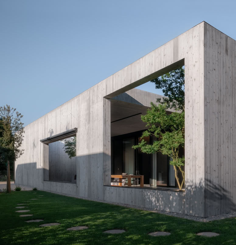La matericità del calcestruzzo esposto definisce il carattere monolitico della villa, accentuando la semplicità formale e il forte legame con la luce naturale.