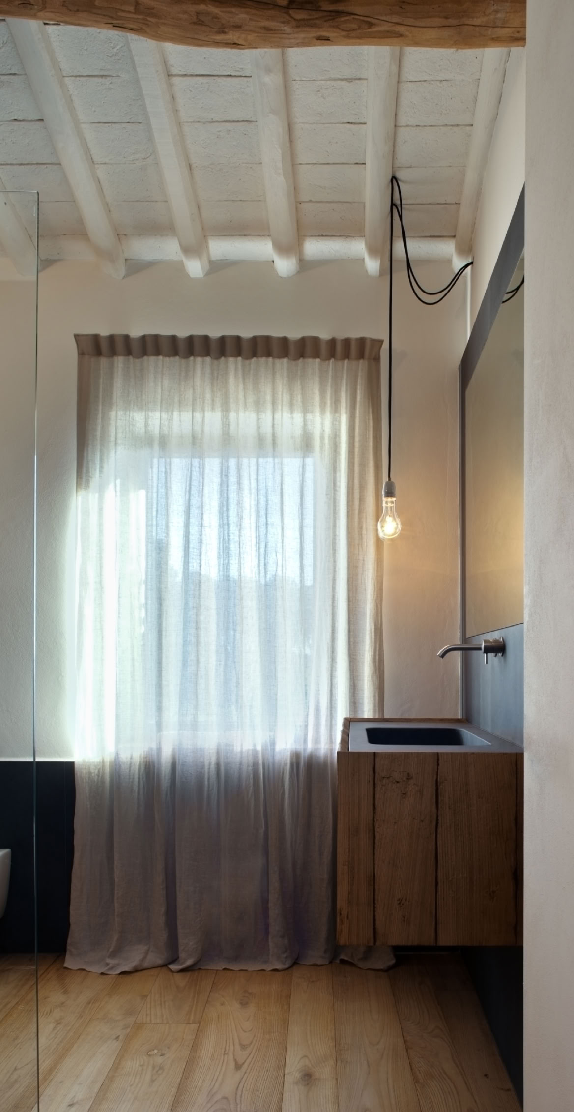 Bagno degli ospiti con soffitti sbiancati nel rustico in Toscana progettato da MIDE architetti.
