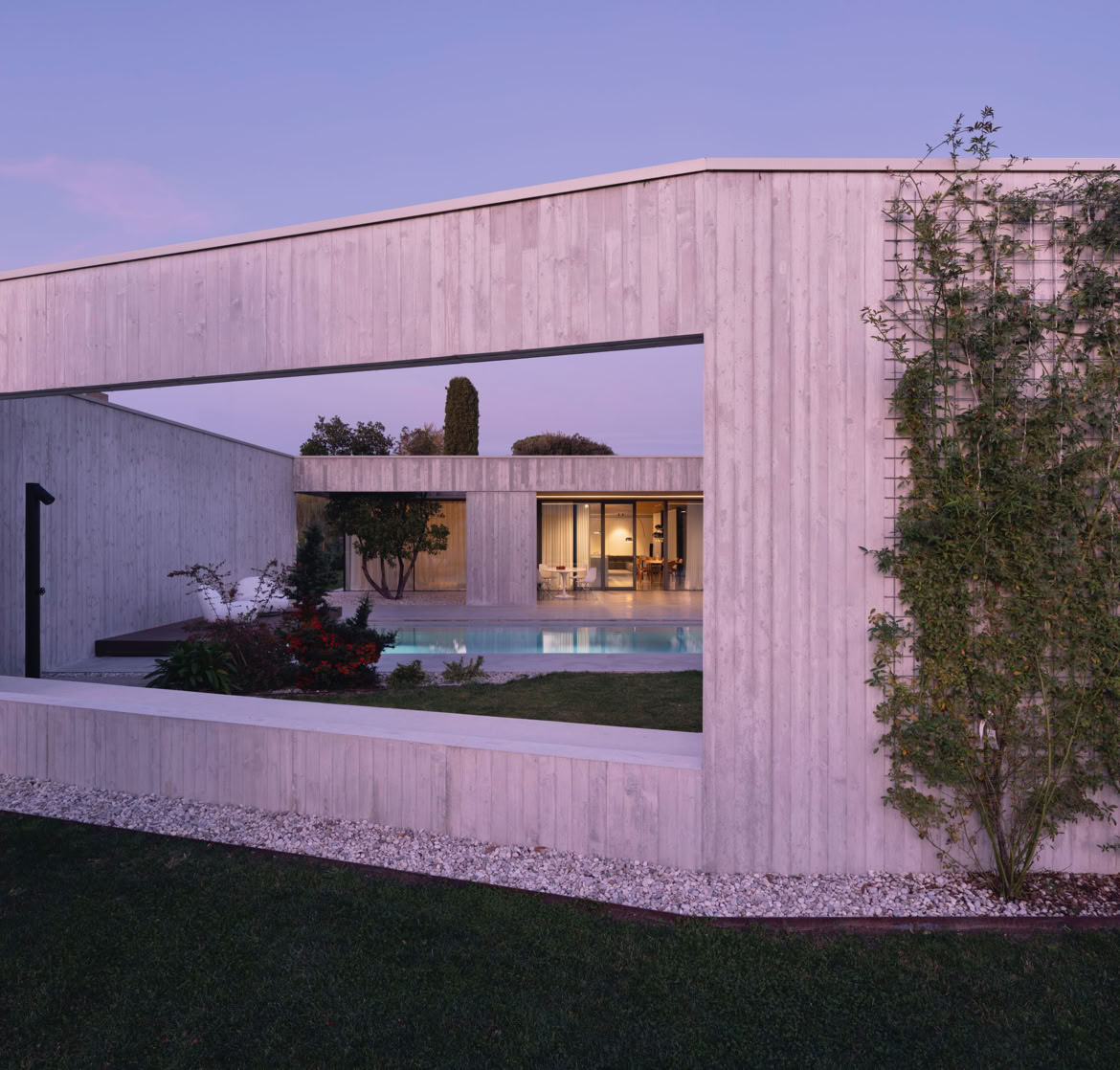 Vista esterna della villa a San Donà di Piave progettata da MIDE architetti immersa nel verde e disegnata con geometrie pulite che regalano privacy all'abitazione.