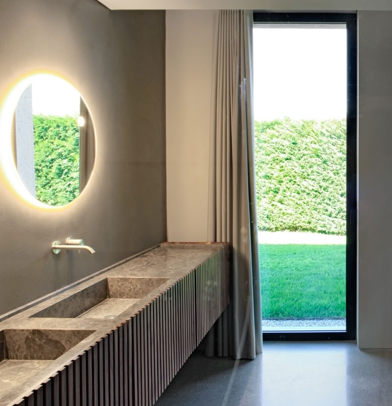 Suite padronale con bagno e cabina armadio affacciata sul parco, pensata come spazio intimo e luminoso.