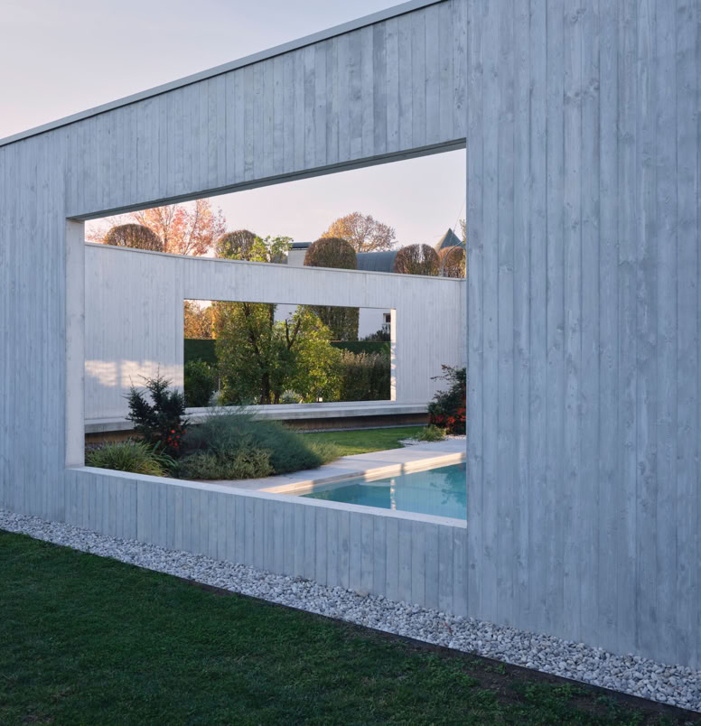 Vista esterna della villa a San Donà di Piave progettata da MIDE architetti immersa nel verde e disegnata con geometrie pulite che regalano privacy all'abitazione.