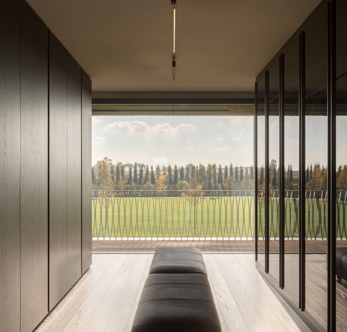 Guardaroba con vista sul parco, annesso alla camera padronale della villa in mattoni progettata da MIDE architetti.
