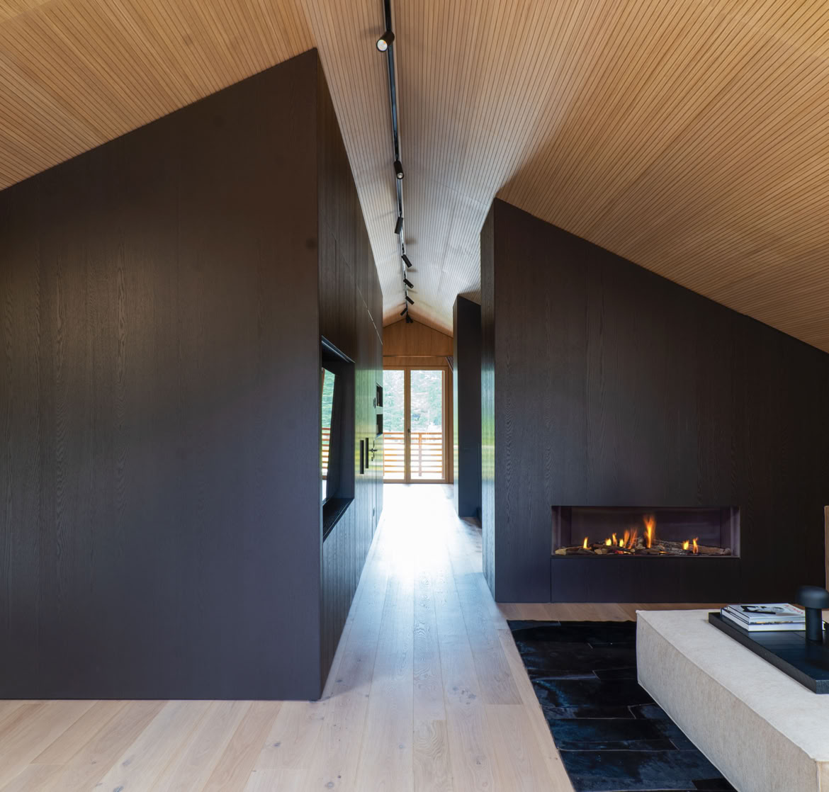 Ampio soggiorno arredato con divano e poltrone di design, caratterizzato da luce naturale e finiture in legno.
