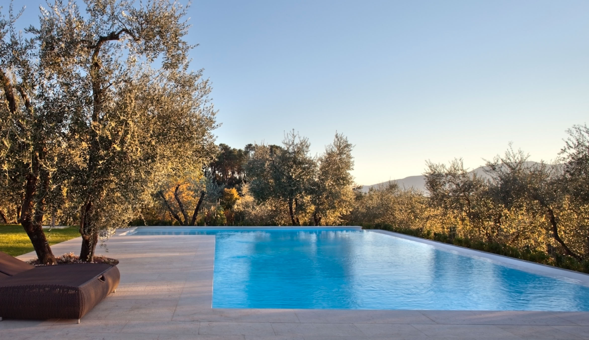 Piscina panoramica integrata nel giardino, pensata per godere del paesaggio naturale e della vegetazione mediterranea.