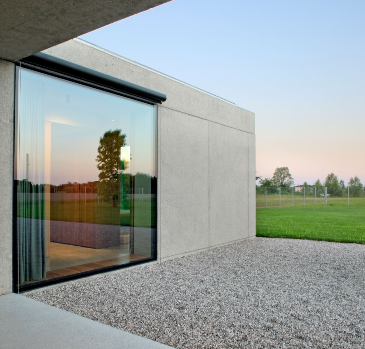 Giardino privato con sistema di recupero delle acque piovane e integrazione della vegetazione nella composizione architettonica.